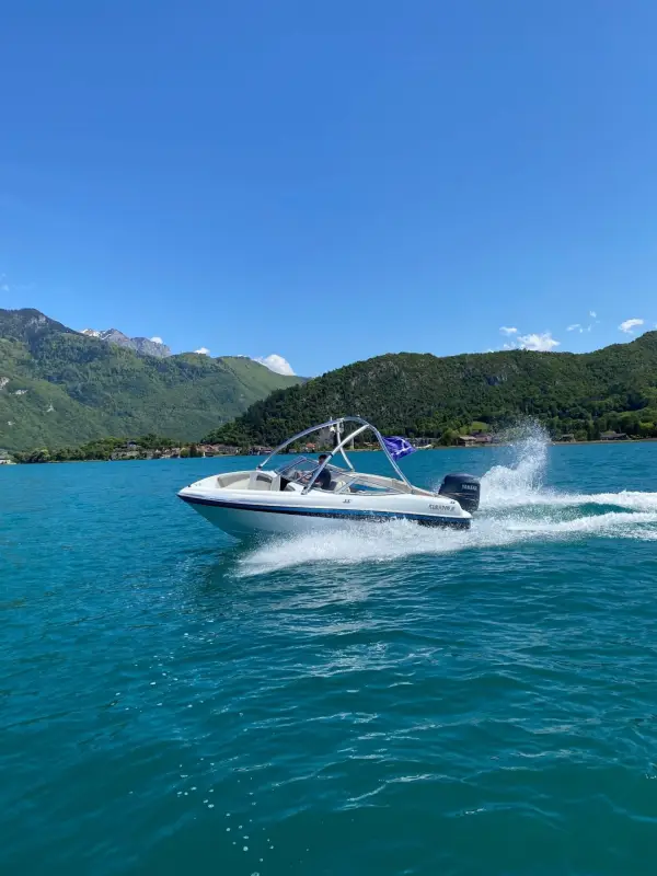 Motorboot gleitet über einen ruhigen Alpensee am frühen Morgen