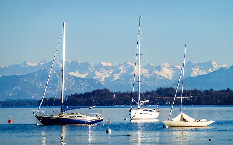 Panoramablick über einen bayerischen See mit Boot und Alpen